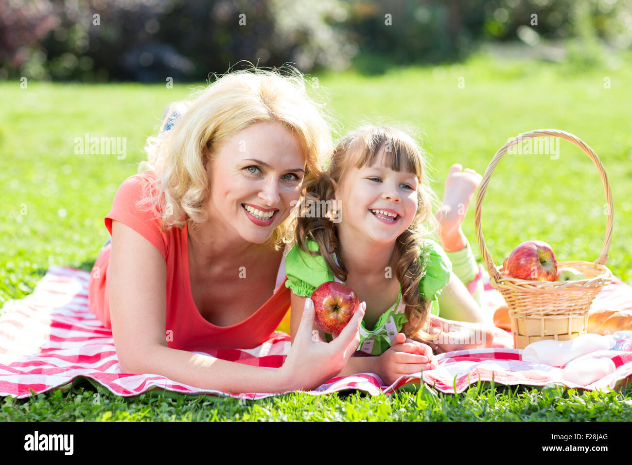 La famiglia felice al concetto di vacanza. Madre e figlia bambina avente picnic a giocare nel parco all'aperto. Foto Stock