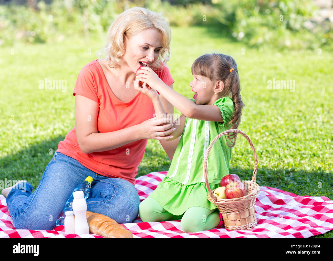 La famiglia felice in vacanza estiva concetto. Madre e figlia bambina avente picnic a giocare nel parco all'aperto. Foto Stock