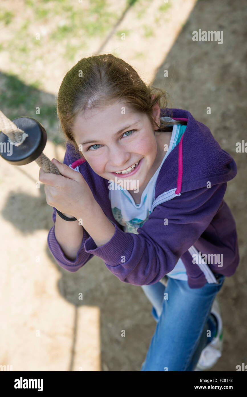 Ragazza salendo sulla corda nel parco giochi, Monaco di Baviera, Germania Foto Stock