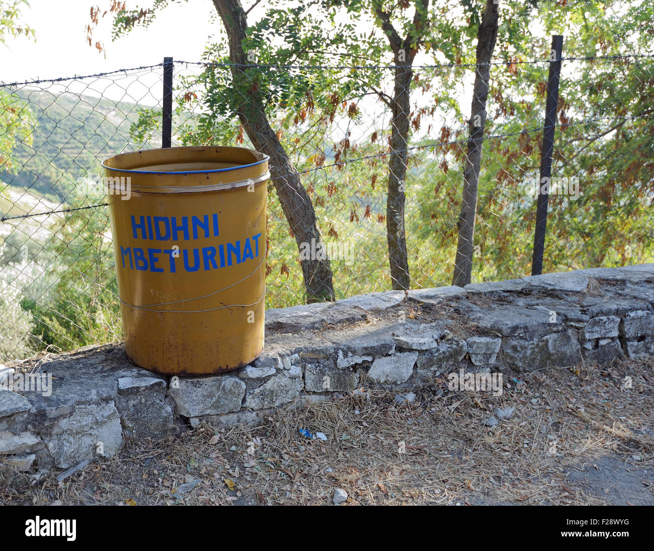 Un marrone spazzatura con la formulazione "Hidhni mbeturinat' vicino Kishё e Shelbuemit ne Rubik, la Chiesa dell'Ascensione. Foto Stock