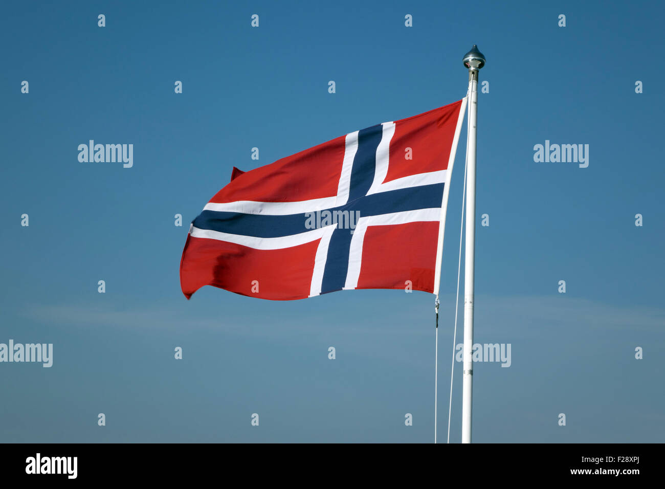 Bandiera norvegese svolazzanti contro un cielo blu Foto Stock