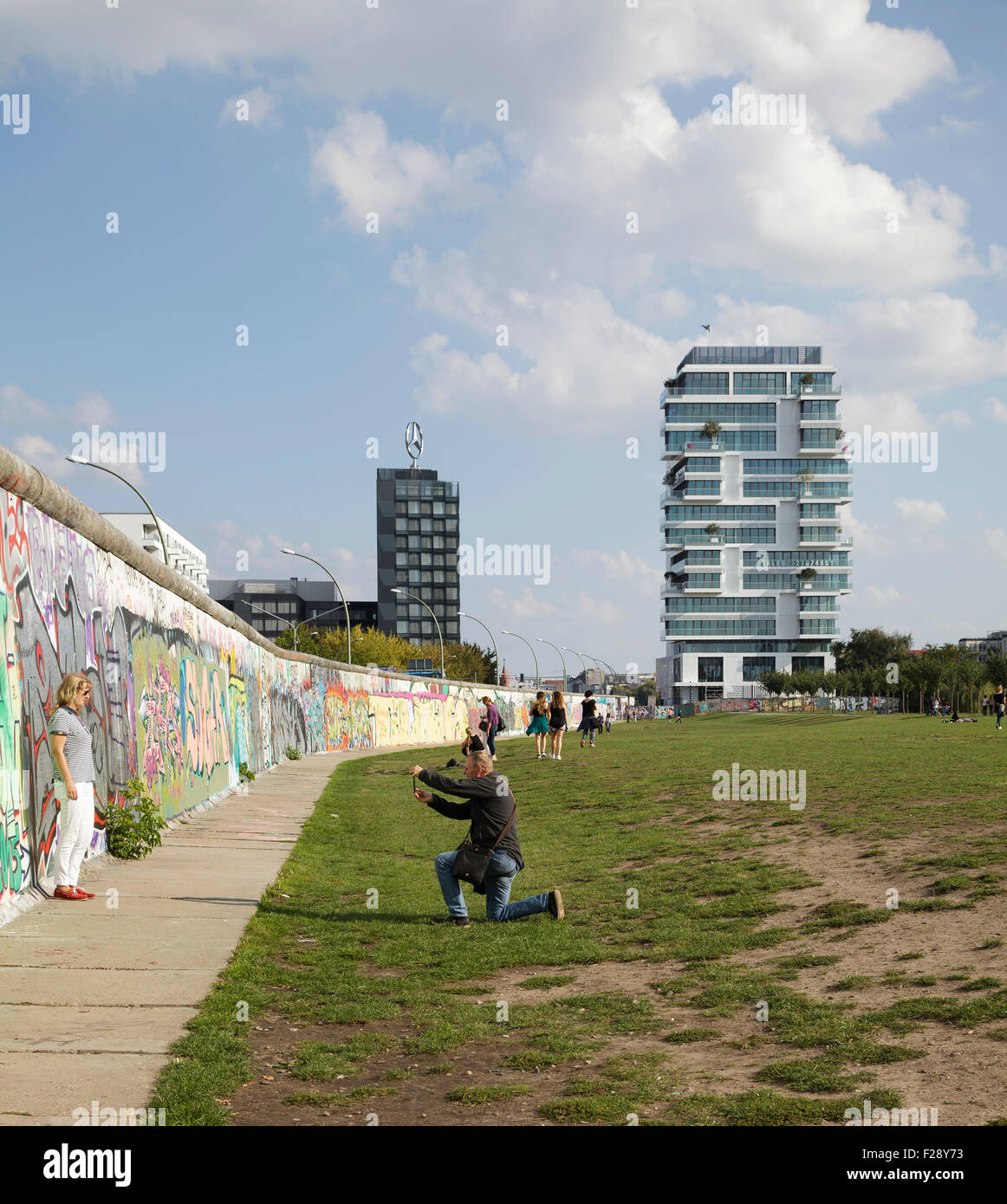 Persone nella ex morte striscia in East Side Gallery con un nuovo appartamento di lusso isolato dietro, Berlino, Germania Foto Stock