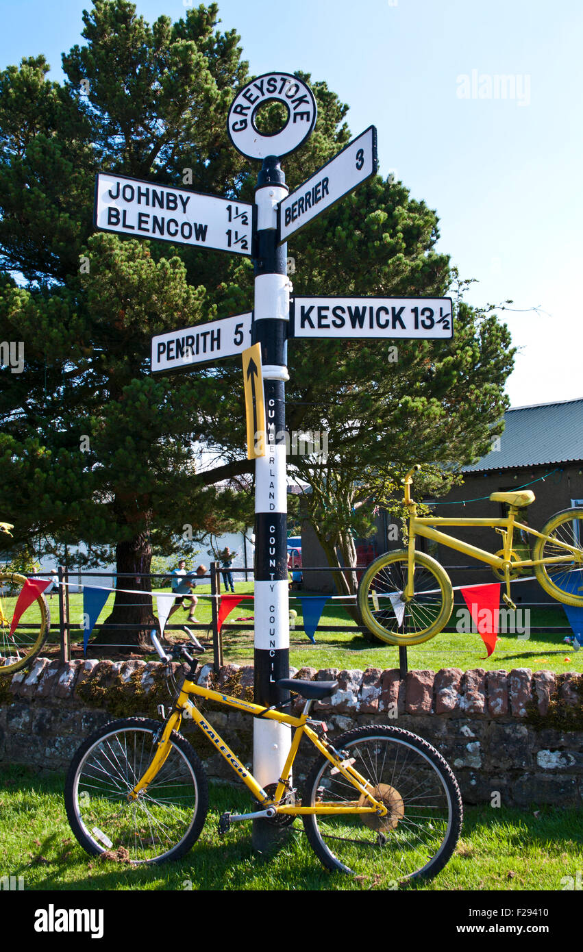 Decorate bikes confinanti con gli scolari giochi dal cartello a Greystoke, Cumbria sul percorso del Tour della Gran Bretagna 2015 Foto Stock