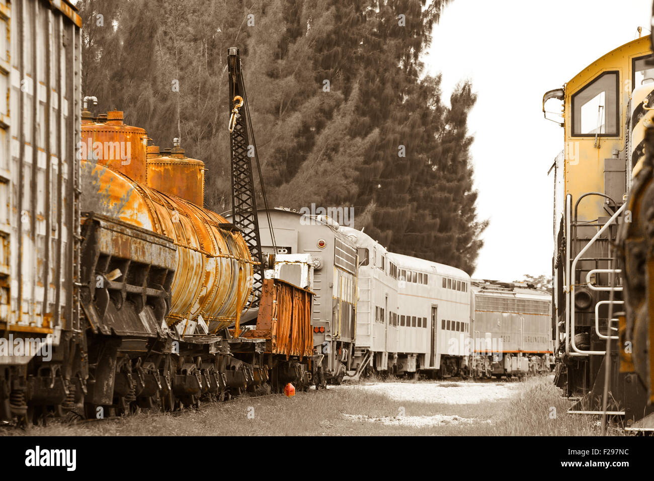Di vecchi treni con vetture di navi cisterna e di autovetture su un trainyard. Foto Stock