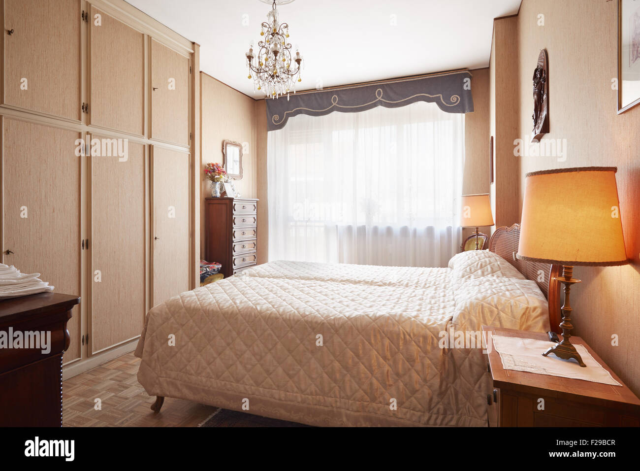 Vecchia camera da letto con letto queen size nella casa accogliente Foto Stock