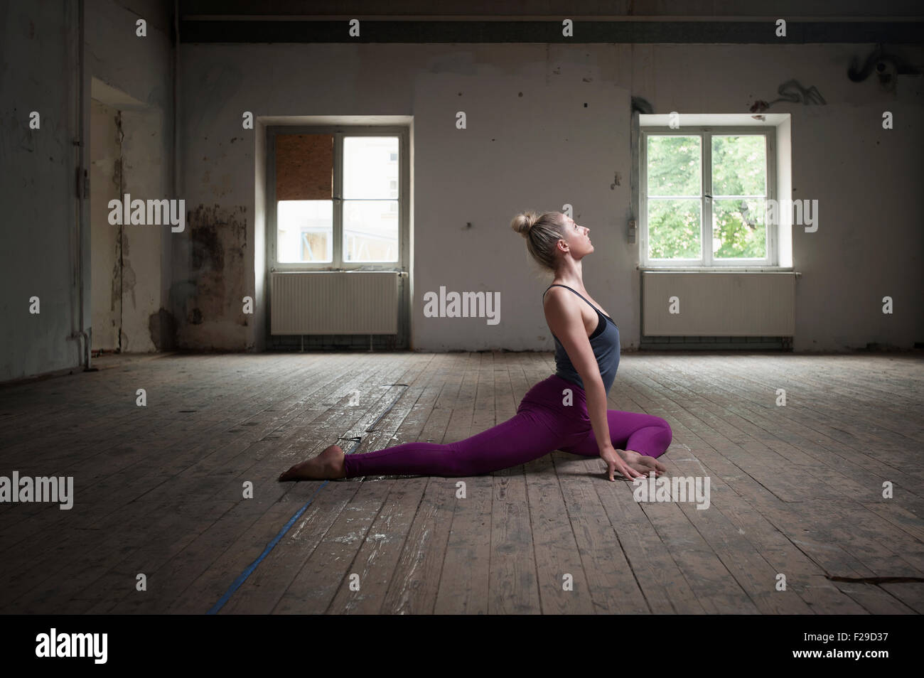 Metà donna adulta pratica pigeon pongono in studio di yoga, Monaco di Baviera, Germania Foto Stock