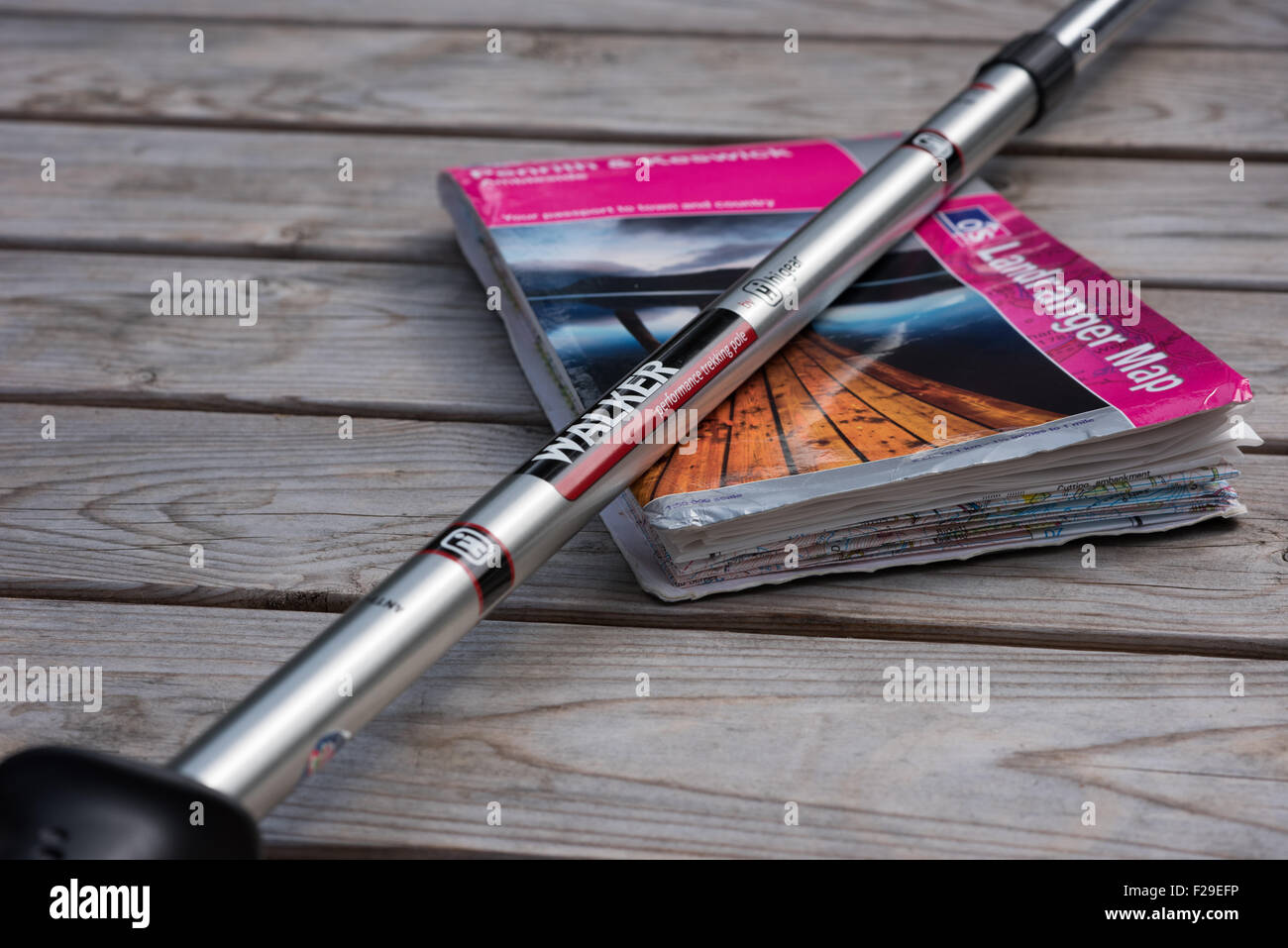 Parte di un alluminio Walking palo in appoggio su una panca in legno su un Ordnance Survey mappa del Distretto del Lago, Cumbria Foto Stock