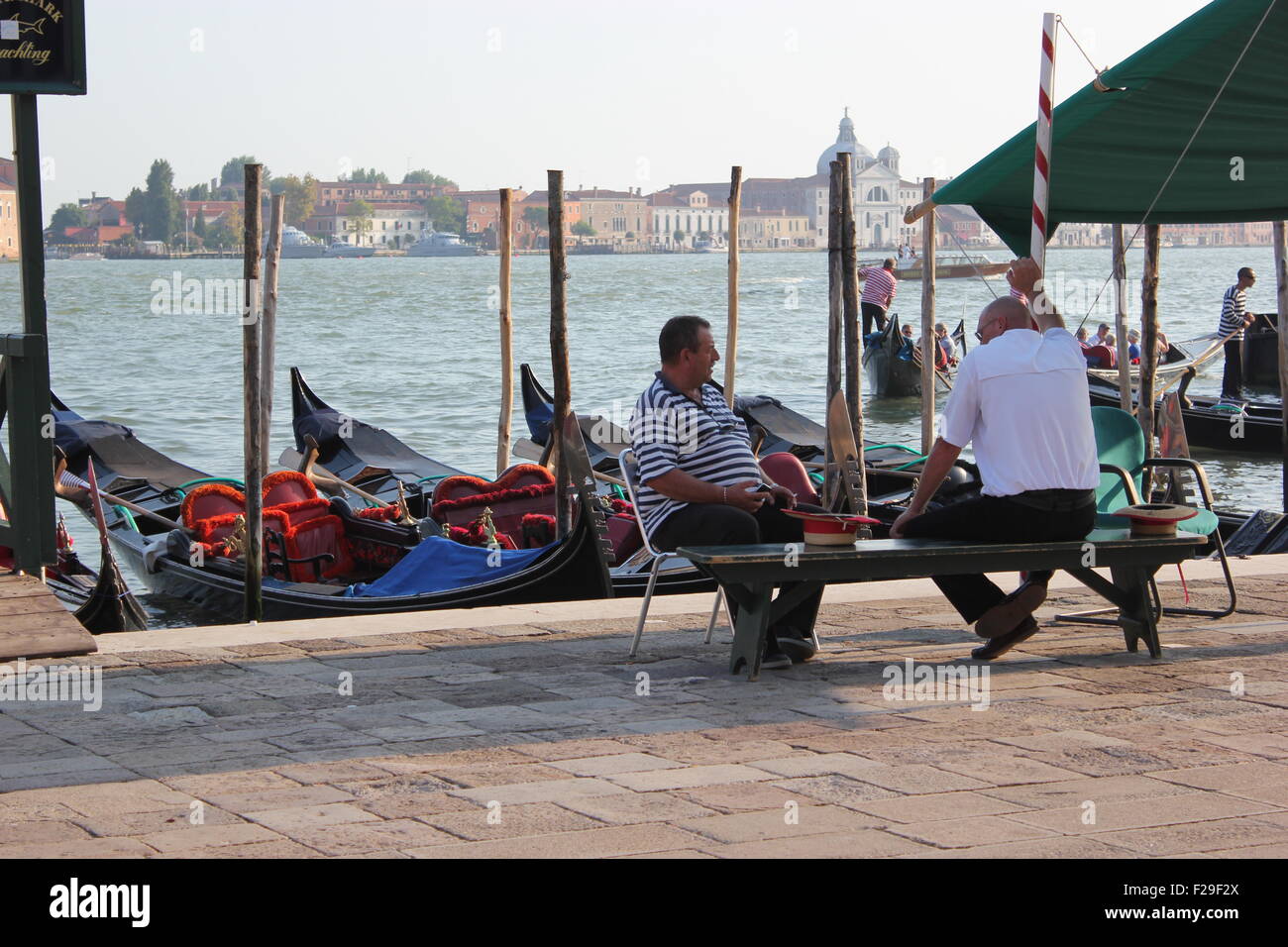 Due uomini avente una conversazione mentre seduto accanto a un dock Foto Stock