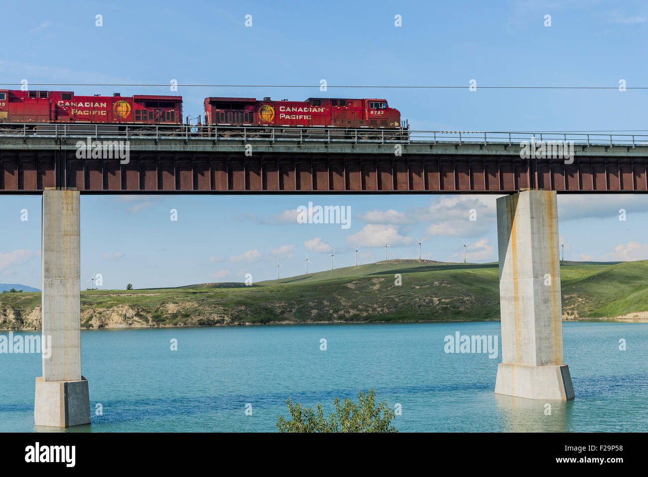 Treno merci attraversa il ponte sopra il vecchio serbatoio, in prossimità del rullo di estrazione Creek, Alberta, Canada Foto Stock