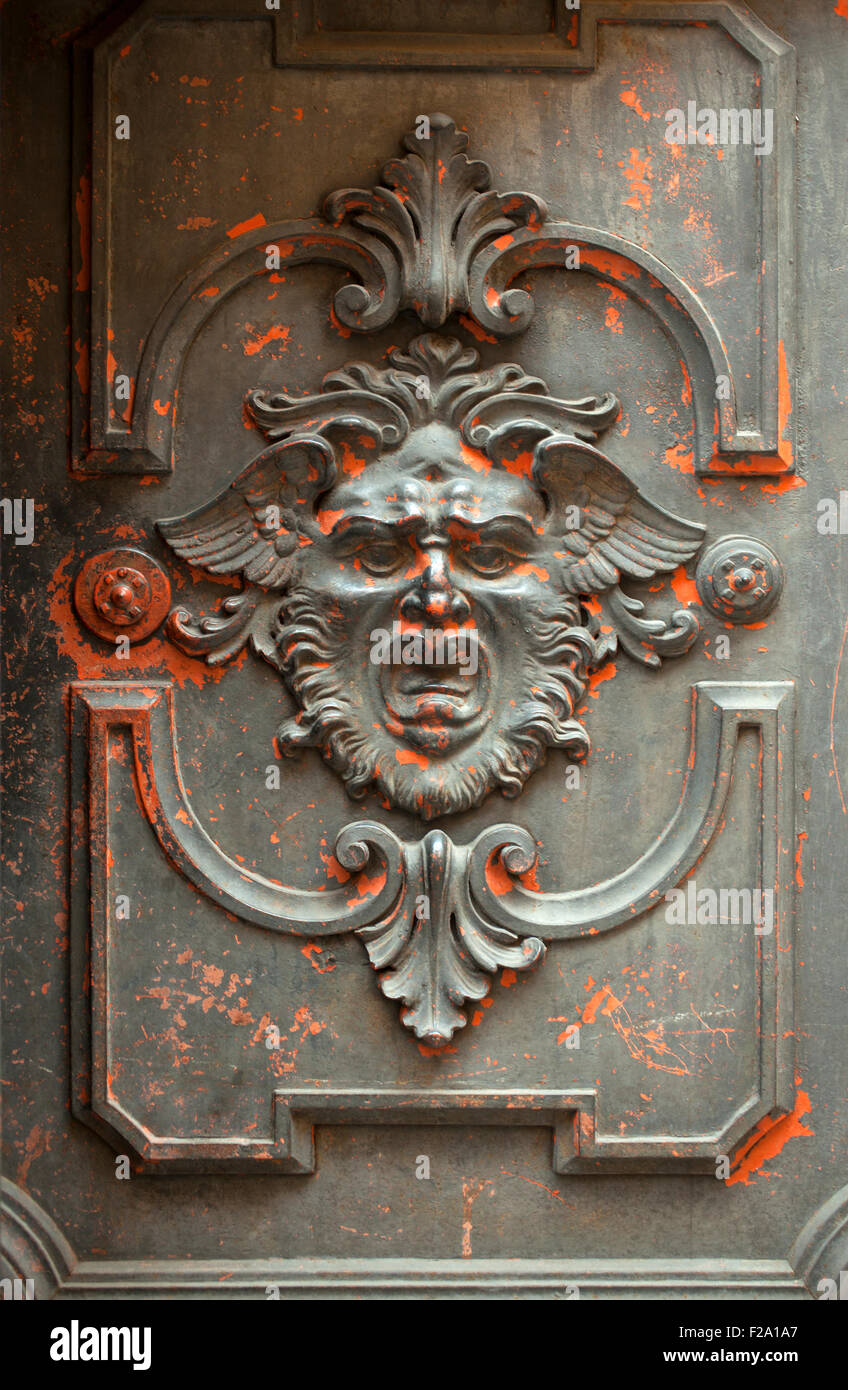 Mostruoso volto scolpito in una porta di legno Foto Stock