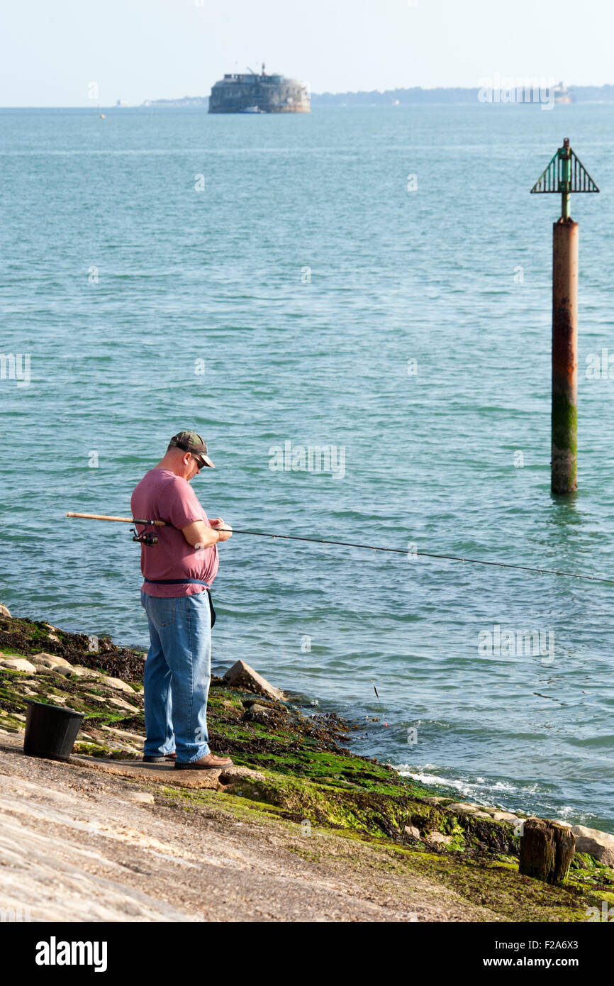 Pescatore solitario con asta e la linea a Southsea seafront England Regno Unito Foto Stock