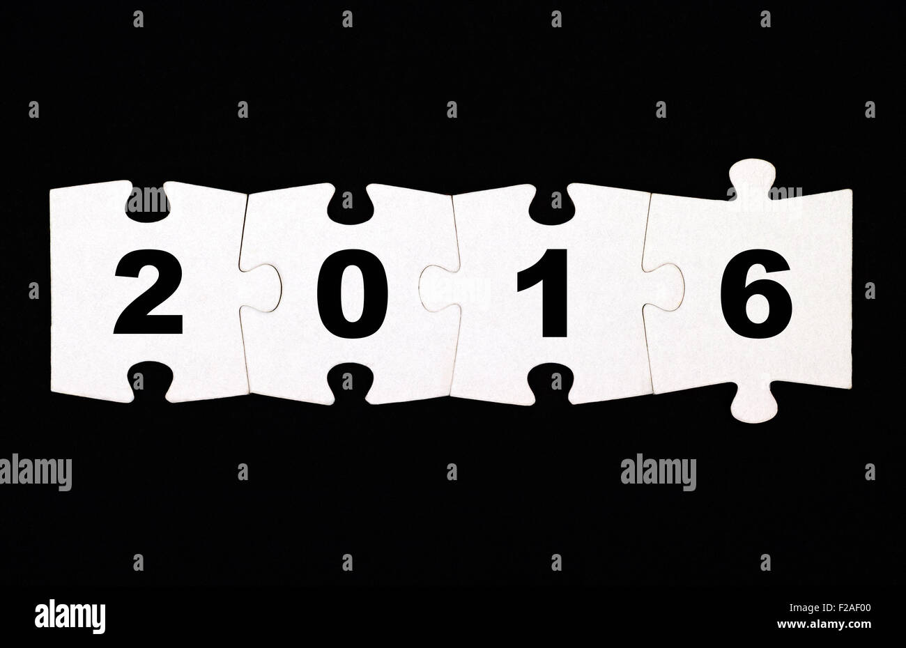 Quattro pezzi di un puzzle con i numeri 2016 sono collegati insieme su sfondo nero Foto Stock