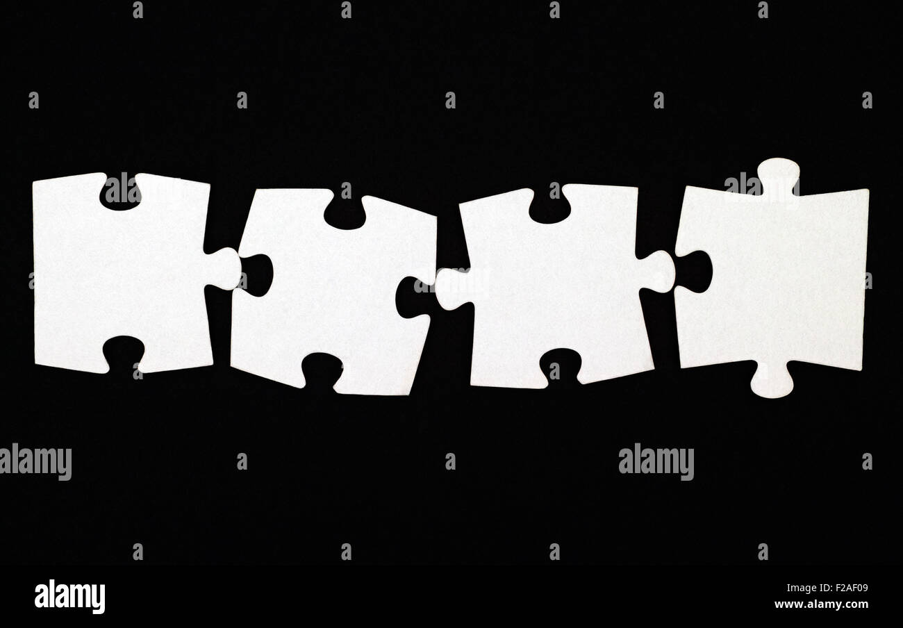 Quattro pezzi di un puzzle su sfondo nero Foto Stock