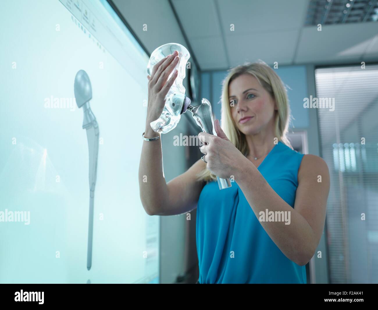 Medical product designer ispezione hip joint modello con schermo grafico Foto Stock