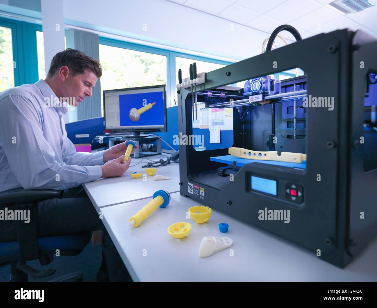 Medical product designer con 3D macchina da stampa con progettazione CAD sullo schermo in fabbrica ortopedico Foto Stock