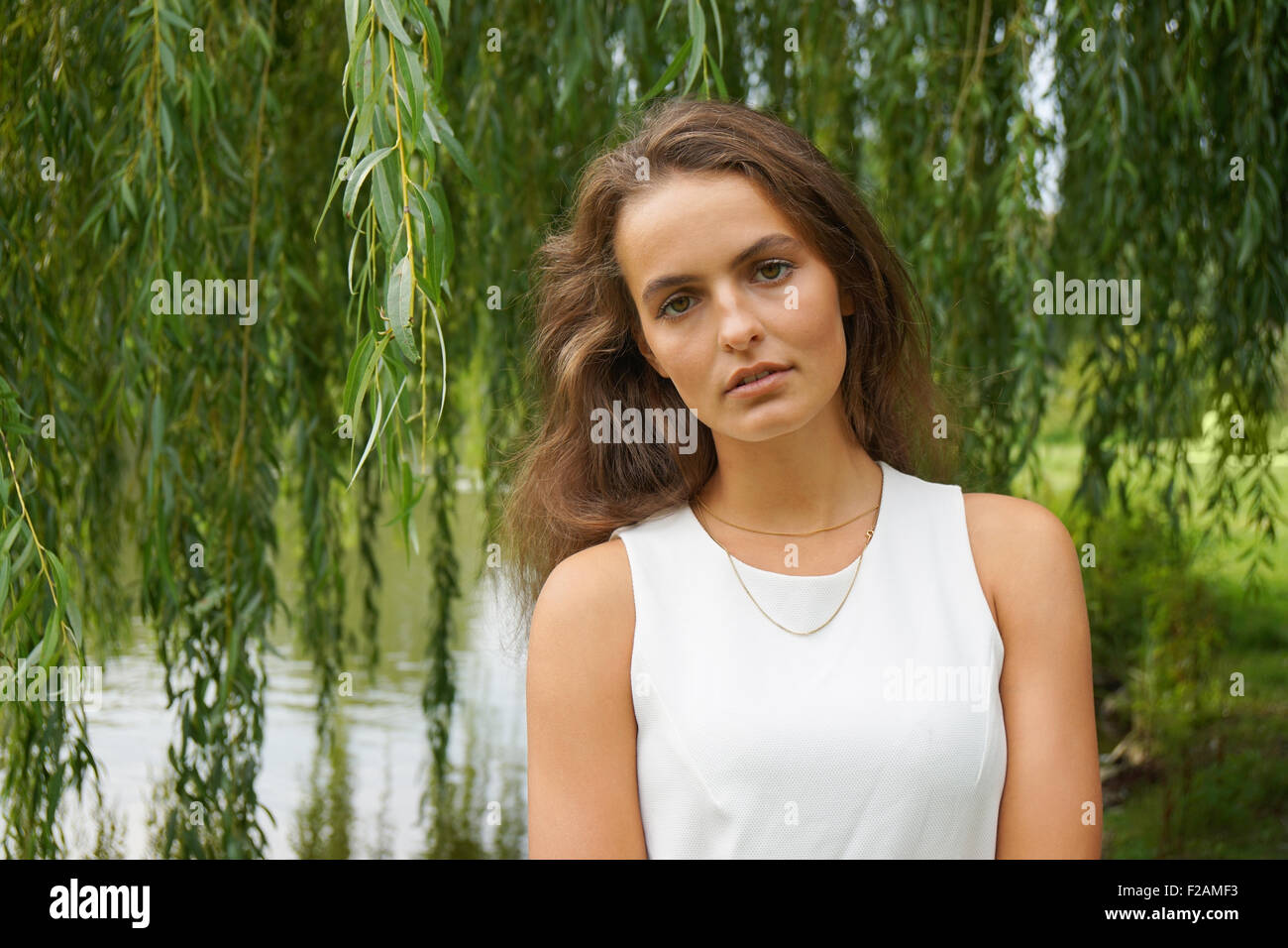 Giovane donna indossa abito bianco in un parco Foto Stock