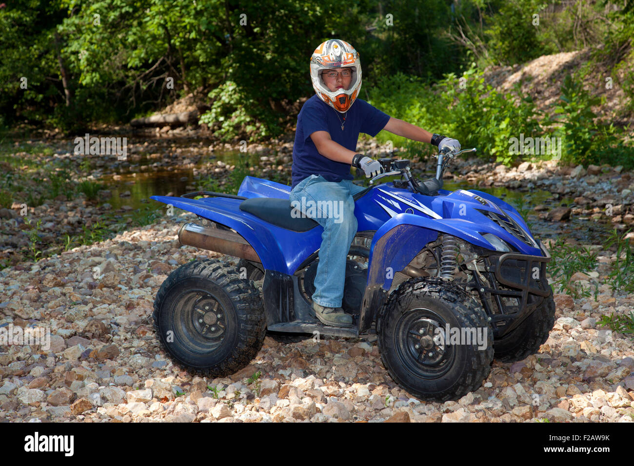 Un ragazzo a cavallo su un ATV blu Foto Stock