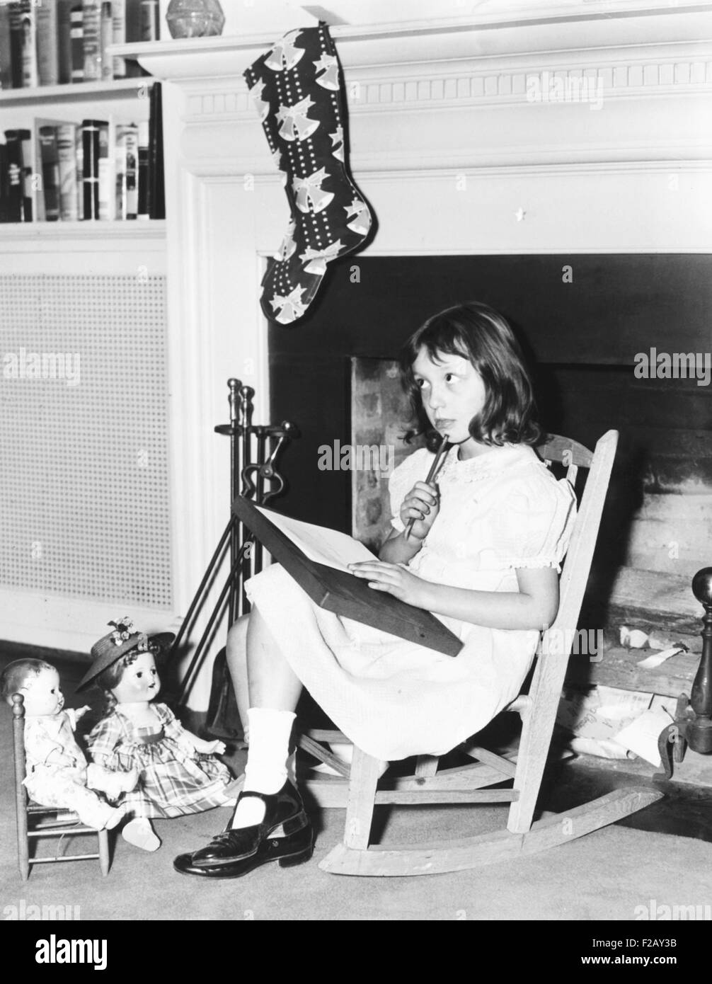 Diana Hopkins, figlia di Harry Hopkins, scrivere una nota per Kris kringle. Si siede davanti alla Casa Bianca il camino in una sedia a dondolo donata da Eleanor Roosevelt. Il vedovo Hopkins e Diana vissuta nella FDR Casa Bianca. Dic. 20, 1939 (CSU 2015 9 889) Foto Stock