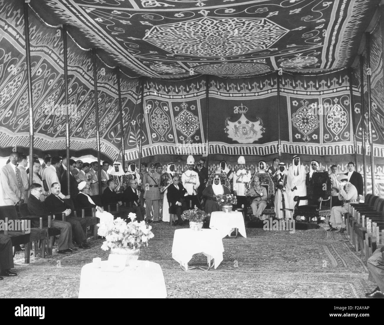 All'interno di un riccamente tapestried tenda, in Iraq le re Faisal si incontra con Re Saud dell Arabia Saudita. Maggio 14, 1957. I due sovrani e il Premier iracheno Nuri As-Said, si sono incontrati per discutere la crisi in Giordania, la cui monarchia fu minacciato dal Pan Arab movimento guidato da Nasser. Gruppo centrale, seduto, L-R: Premier Nuri As-Said; re Saud; re Faisal. (CSU 2015 9 808) Foto Stock