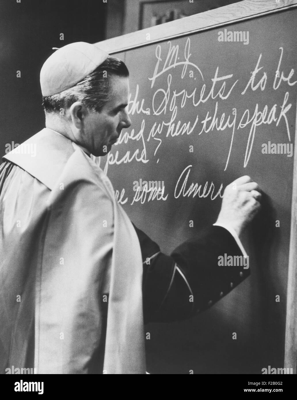 Il Vescovo Fulton Sheen scrivere sulla lavagna durante la trasmissione del suo programma televisivo, la vita vale la pena di vivere. Nov. 1, 1954. Egli scrisse, "sono i sovietici ad essere creduto quando parlano di pace?" ateismo comunista è stato denunciato dal vescovo Sheen. (CSU 2015 9 1145) Foto Stock