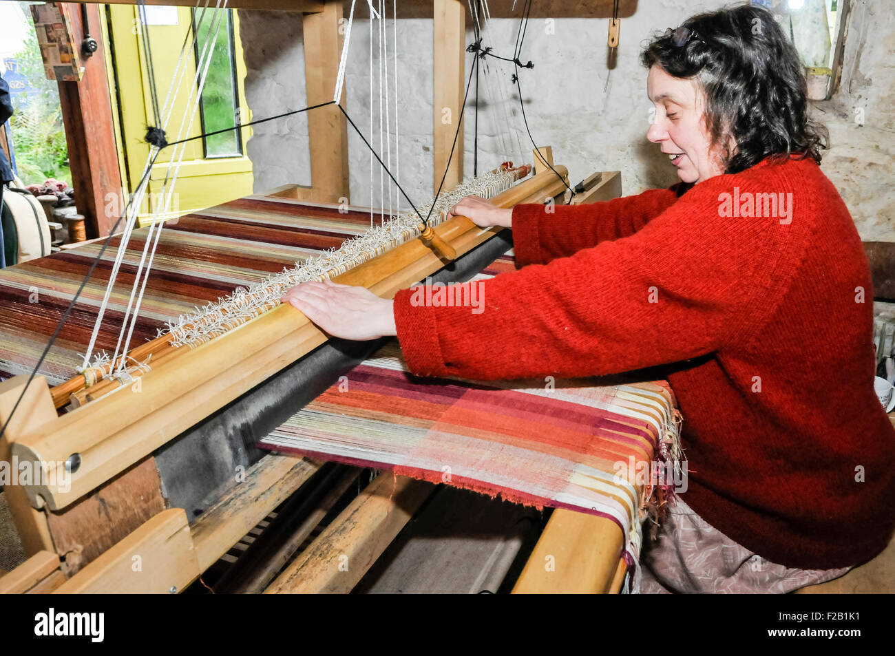 Una donna intrecci tessili Biancheria utilizzando un tradizionale telaio a mano Foto Stock