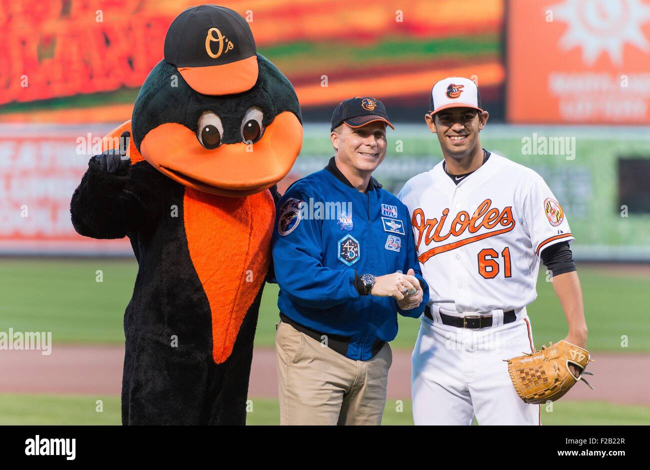 L'astronauta della NASA e Maryland native, Terry Virts, centro in posa per una foto con il Baltimore Orioles mascotte e Orioles pitcher Jason Garcia, destra, dopo aver gettato il cerimoniale di primo passo prima di Boston Red Sox prendere sul Baltimore Orioles a Camden Yards Baseball Stadium il 14 settembre 2015 a Baltimora, Maryland. Virts spendere 199 giorni a bordo della Stazione Spaziale Internazionale. Foto Stock