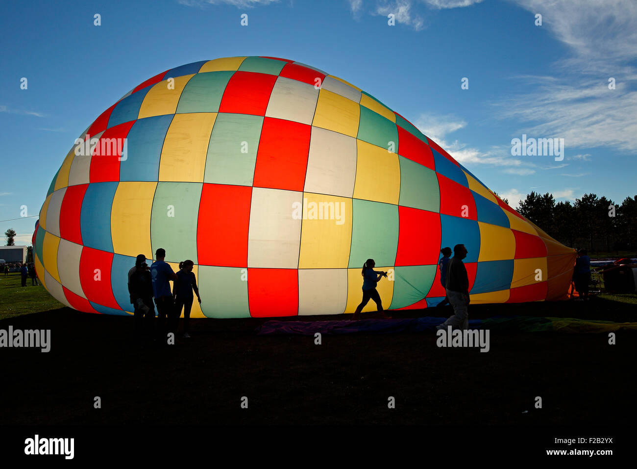 Sagome contro un gonfiaggio di una mongolfiera al trentesimo atlantico annuale International Balloon Fiesta, Sussex, NB, Canada. Foto Stock