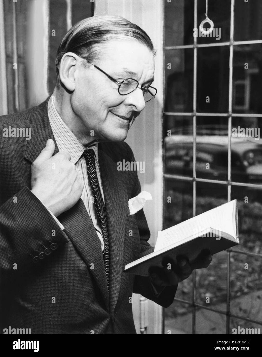T.S. Eliot, sorridente in reminiscence, nov. 10, 1959. Egli è in possesso di un libro contenente alcuni dei suoi primi lavori nel corso di una conferenza stampa presso l'Università di Chicago. Eliot condotta una lettura delle sue opere a nome della poesia moderna associazione che sponsorizza 'poesia Magazine'. Eliot ha avuto la sua prima poesia pubblicato nella rivista nel 1915. - (CSU 2015 5 61) Foto Stock
