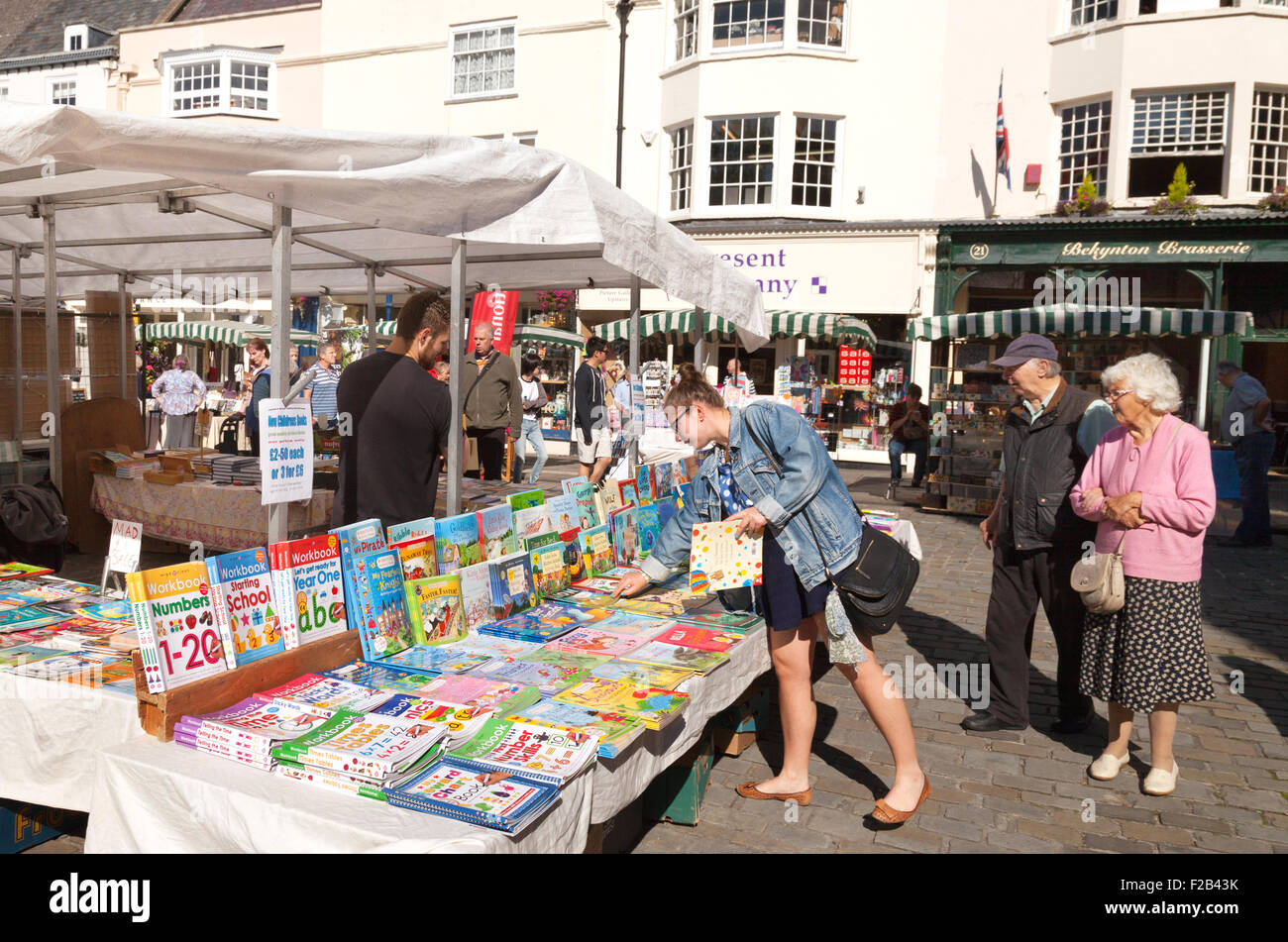 Una donna di acquistare libri in un libro di stallo Pozzi, mercato, pozzi, Somerset England Regno Unito Foto Stock