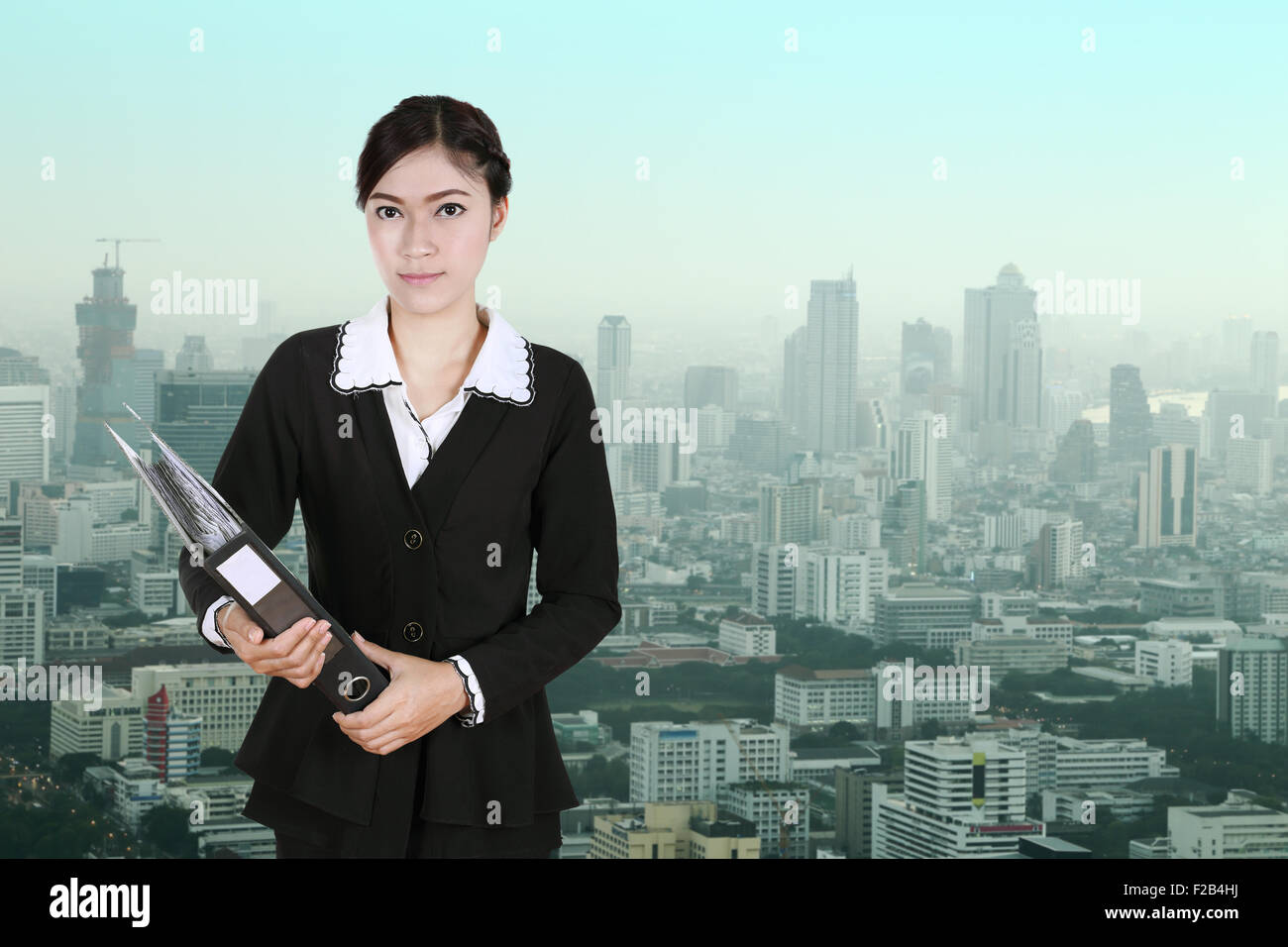 Business donna apposita cartella documenti con sfondo della città Foto Stock