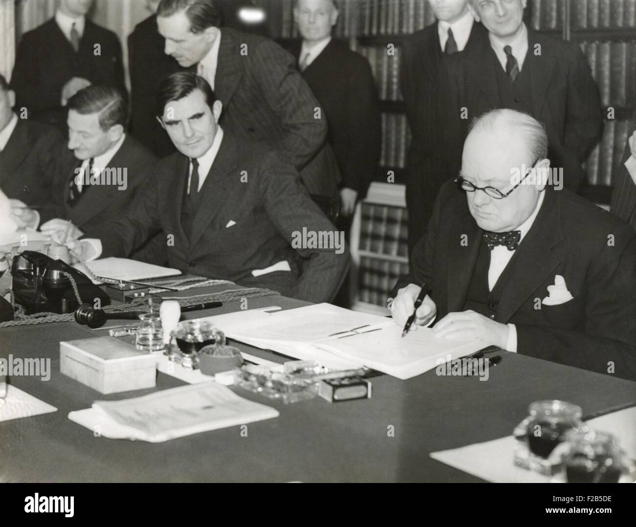 Winston Churchill firma la "Lend Lease' contratto di affitto basi britanniche per gli Stati Uniti Marzo 11, 1941. Dalla sua scrivania al 10 di Downing Street, Churchill e U.S. Ambasciatore, John G. Winant, segno 'un atto a promuovere ulteriormente la difesa degli Stati Uniti". - (BSLOC 2014 17 35) Foto Stock