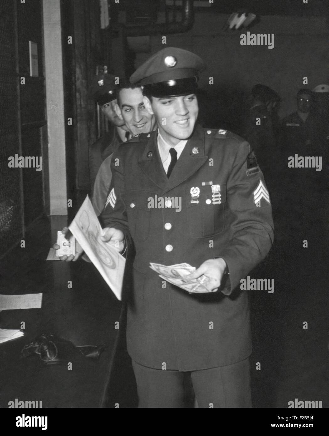 Sgt. A. Elvis Presley, XXXII blindata, 3° Armored Div. riscuote il suo ultimo pagare come egli ri-entra nella vita civile. Il 5 marzo 1960. - (BSLOC 2014 17 108) Foto Stock