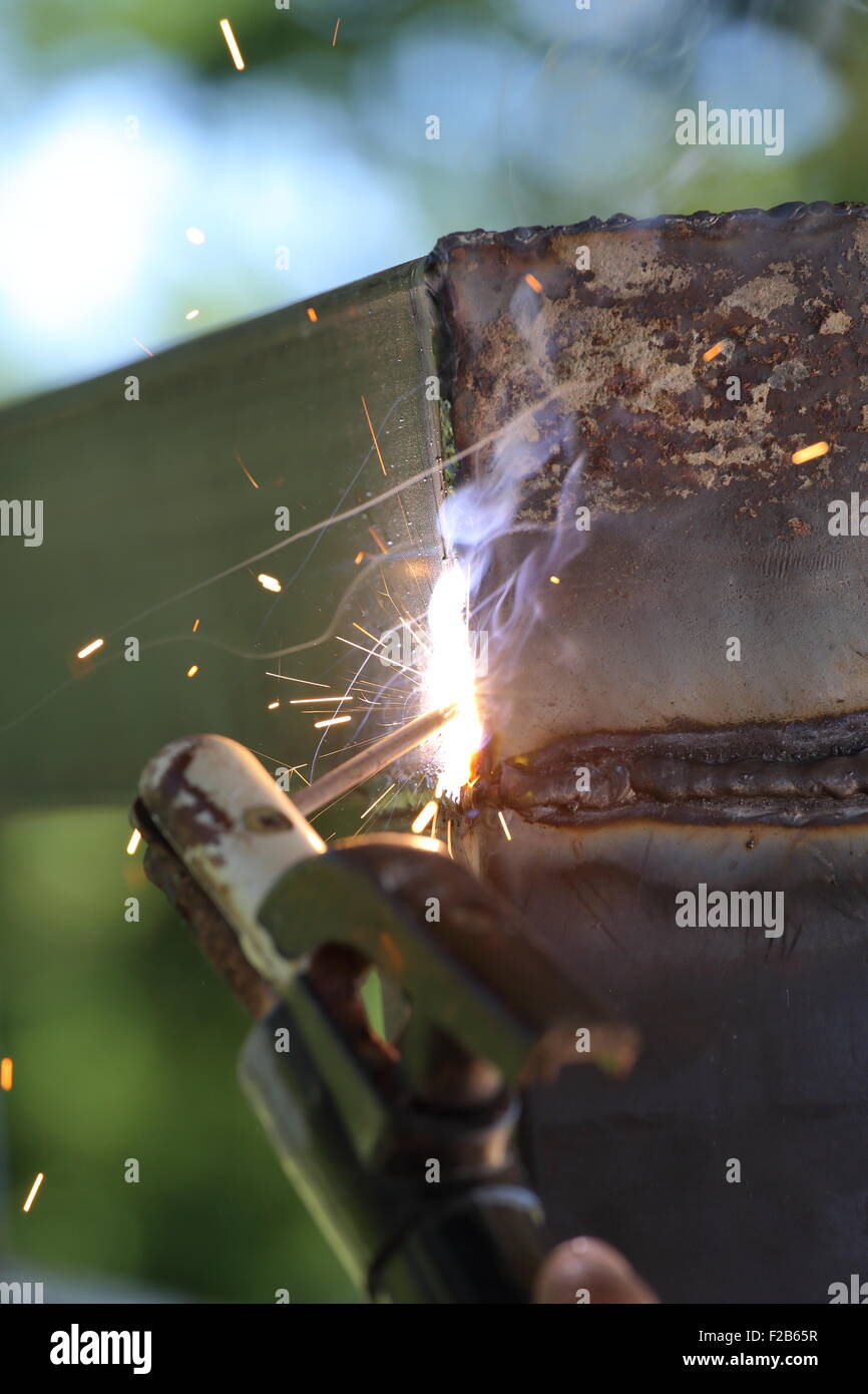 Vicino la mano del lavoratore di metallo di saldatura Foto Stock