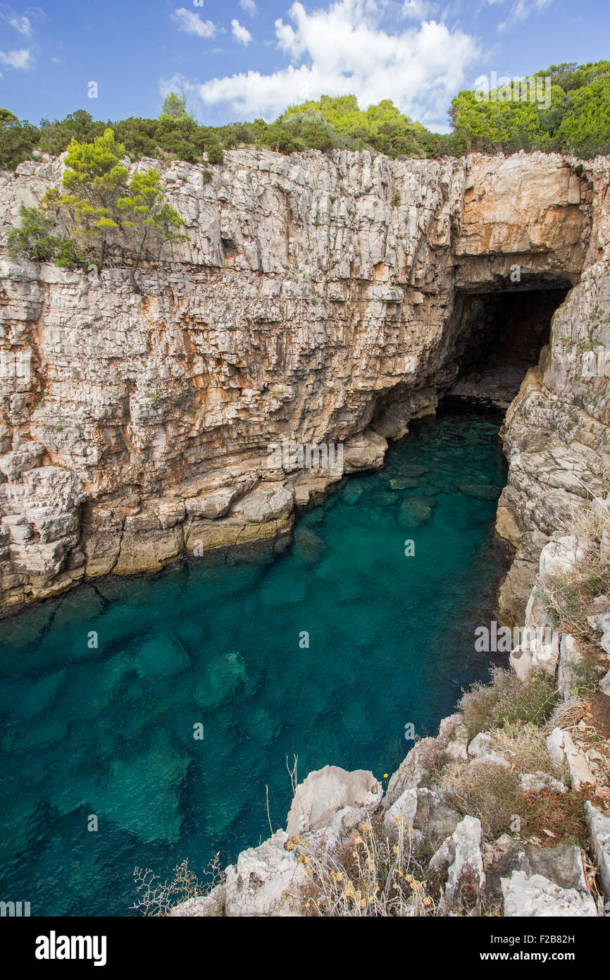 Svuotare il mare grotta, acque poco profonde e ripide e rupe robusto presso l'isola di Lokrum in Croazia. Foto Stock