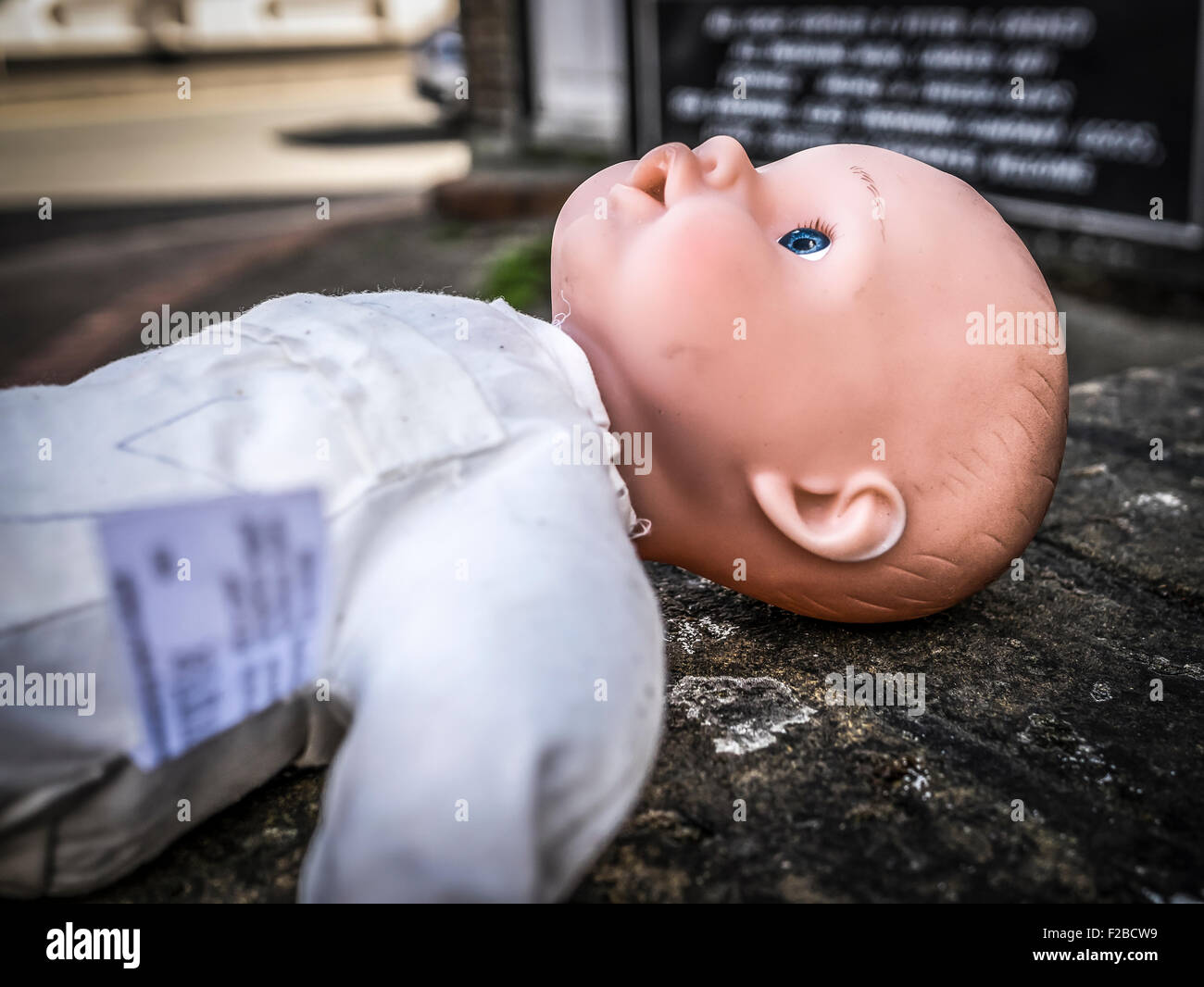 Bambola abbandonata del bambino ha lasciato su un muro Foto Stock