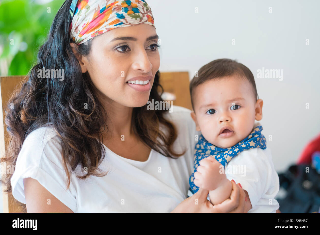 Multi etnico - famiglia donna ispanica con baby figlio sul suo giro Foto Stock