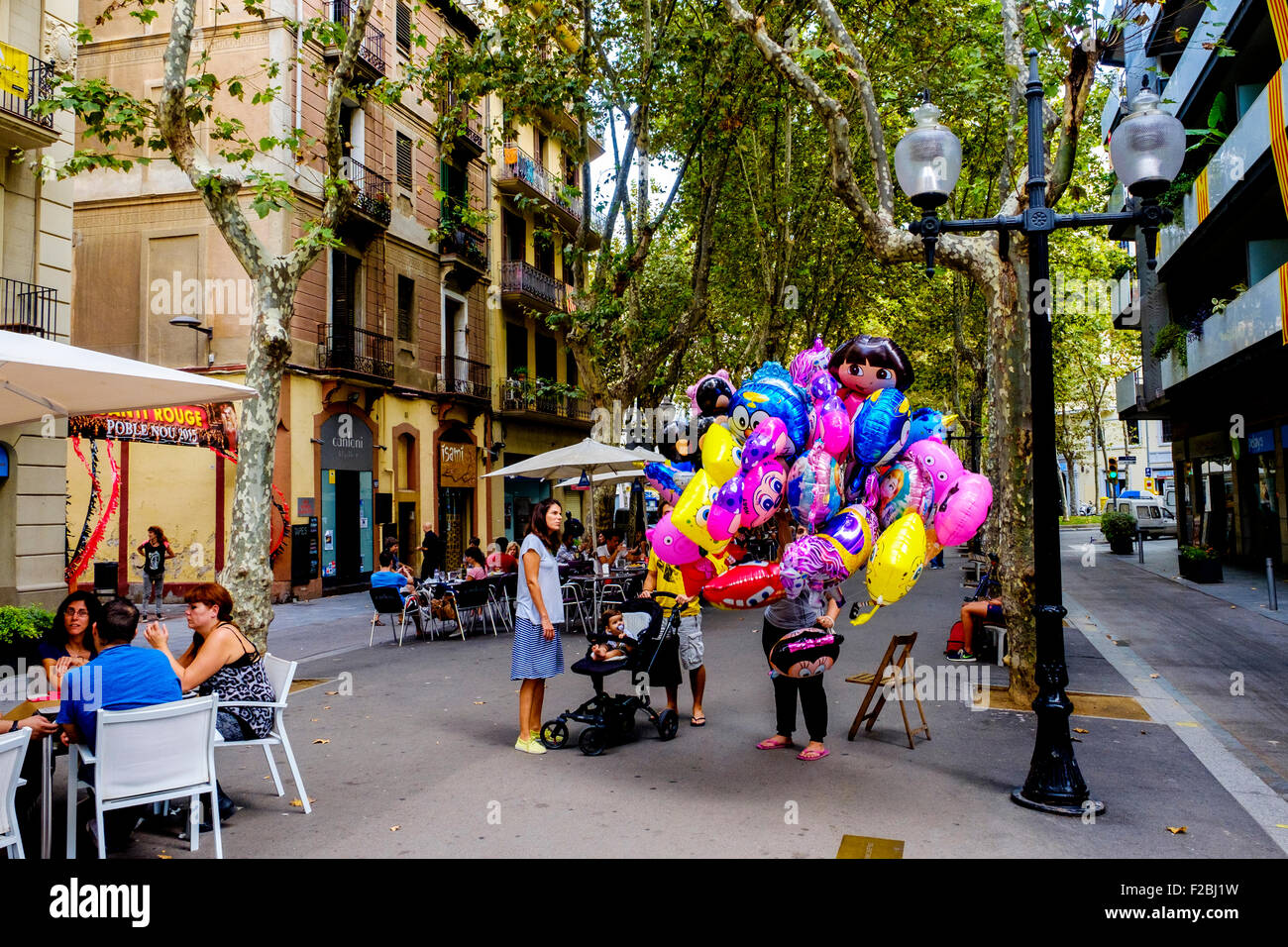 Persone che acquistano palloncini da un venditore ambulante in Rambla del Poblenou, Barcellona, in Catalogna, Spagna Foto Stock