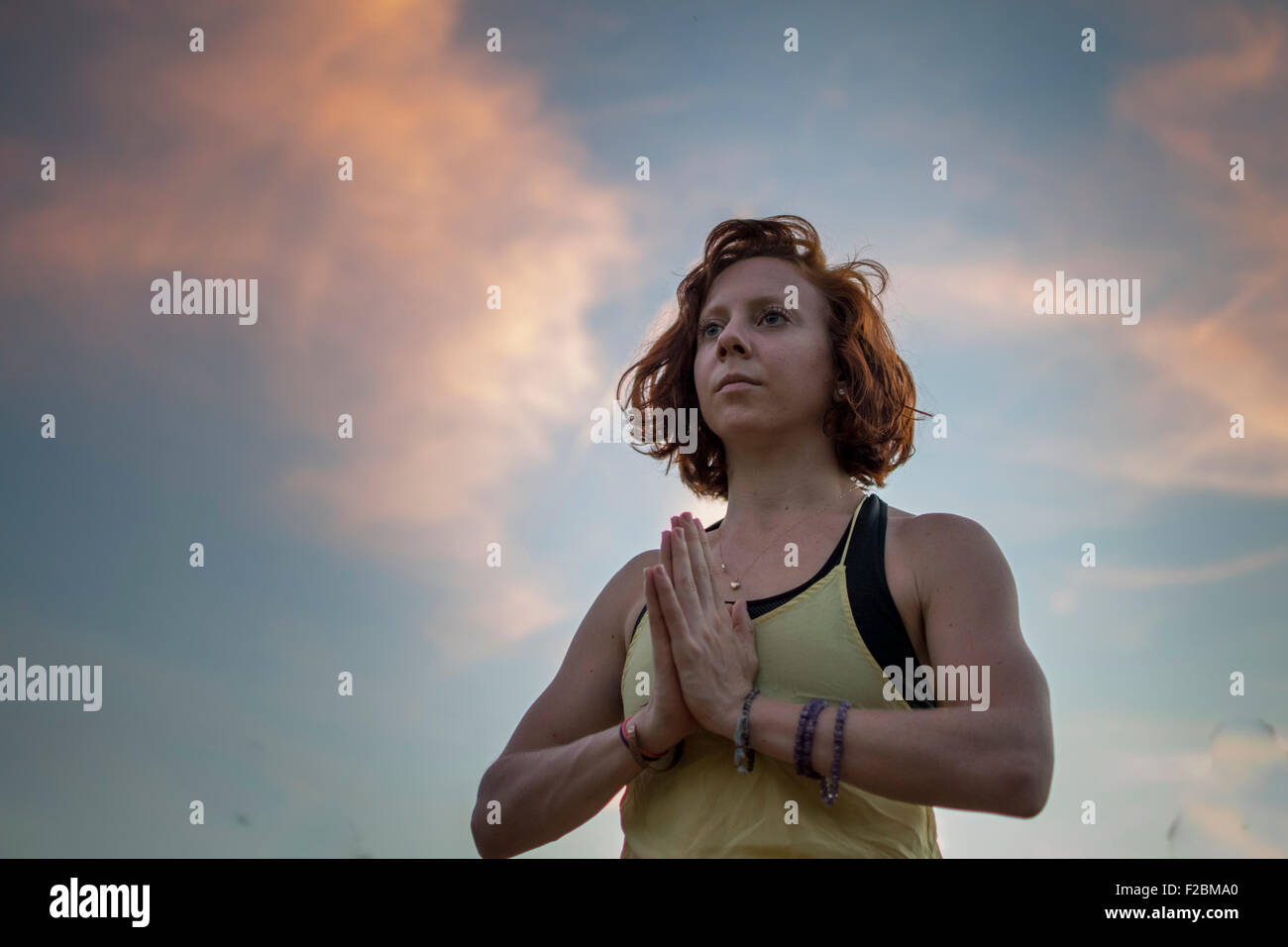 Attraente giovane donna a praticare yoga nel parco (Preghiera mani) (la posizione dell'albero) Foto Stock