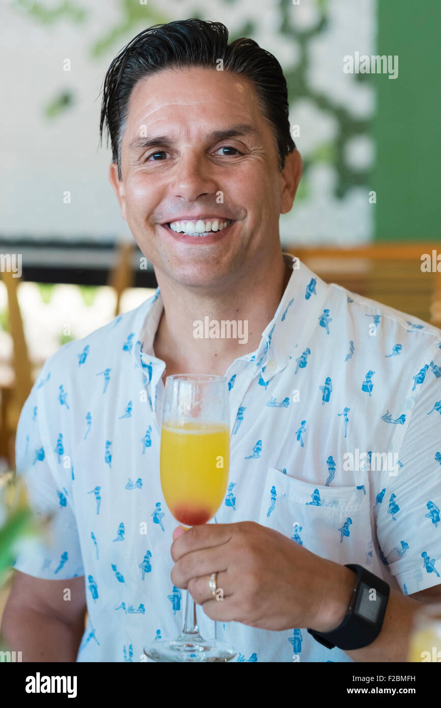 Uomo con cocktail di mimosa Foto Stock