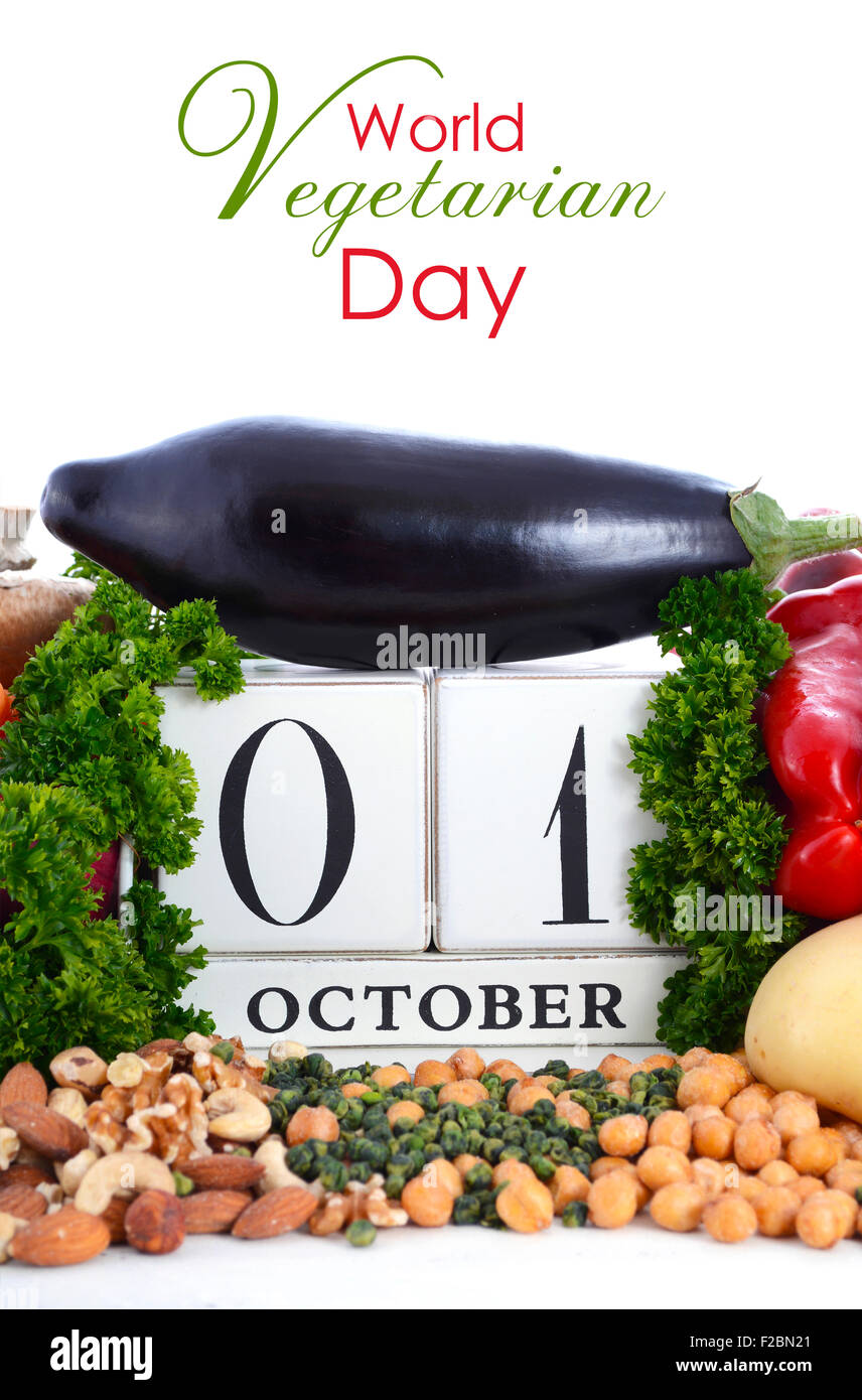 Giornata Mondiale del Vegetarismo, 1 ottobre, legumi, noci e legumi che circonda vintage in legno in stile calendario su sfondo bianco. Foto Stock
