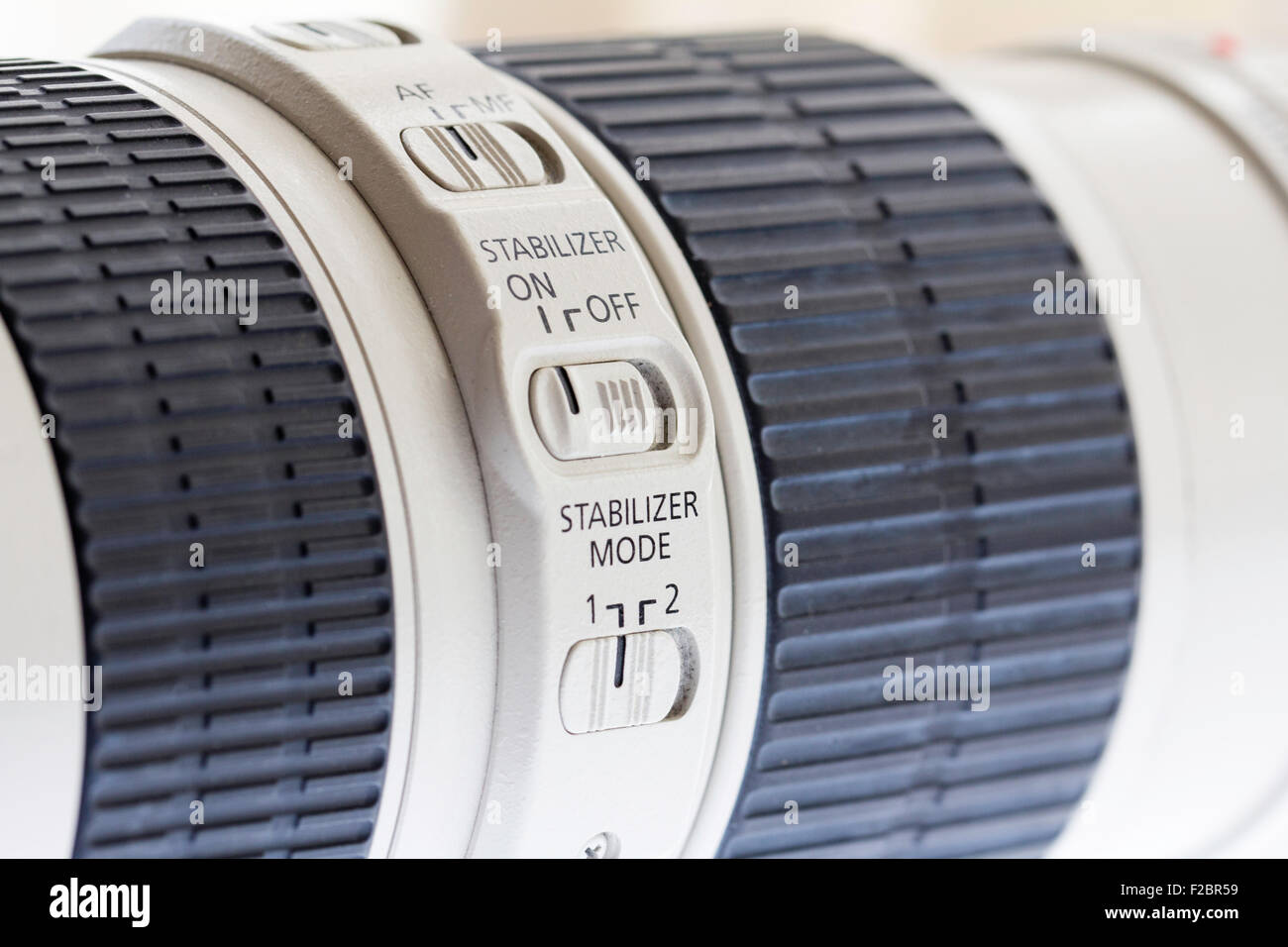 Close up di Canon l obiettivo 70-200mm F4 che mostra il pannello di controllo sul lato del corpo dell'obiettivo con lo stabilizzatore e il selettore di modalità e nero impugnatura in gomma. Foto Stock