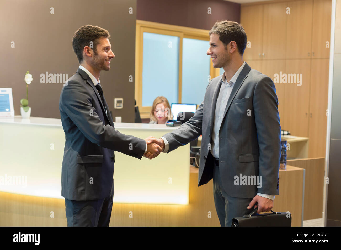 Due imprenditori si stringono la mano in ufficio ricevimento Foto Stock