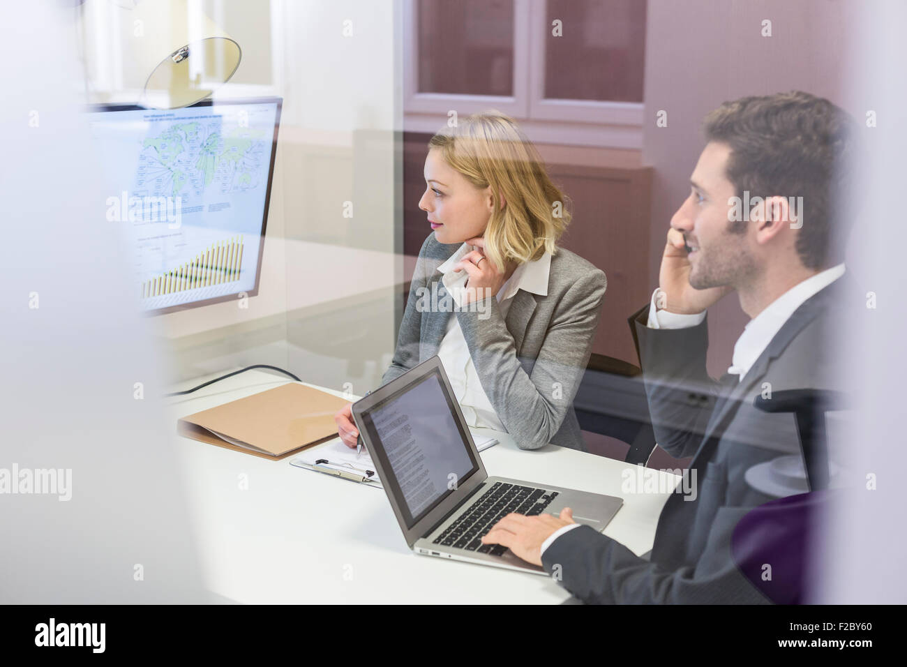 Colleghi di lavoro che lavora sul computer portatile in ufficio e sale riunioni Foto Stock