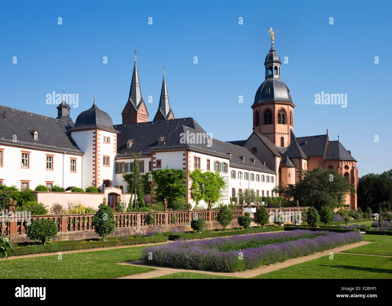 Il giardino del convento con la Basilica di San Marcellino e Pietro, ex Abbazia Benedettina Seligenstadt, Hesse, Germania Foto Stock