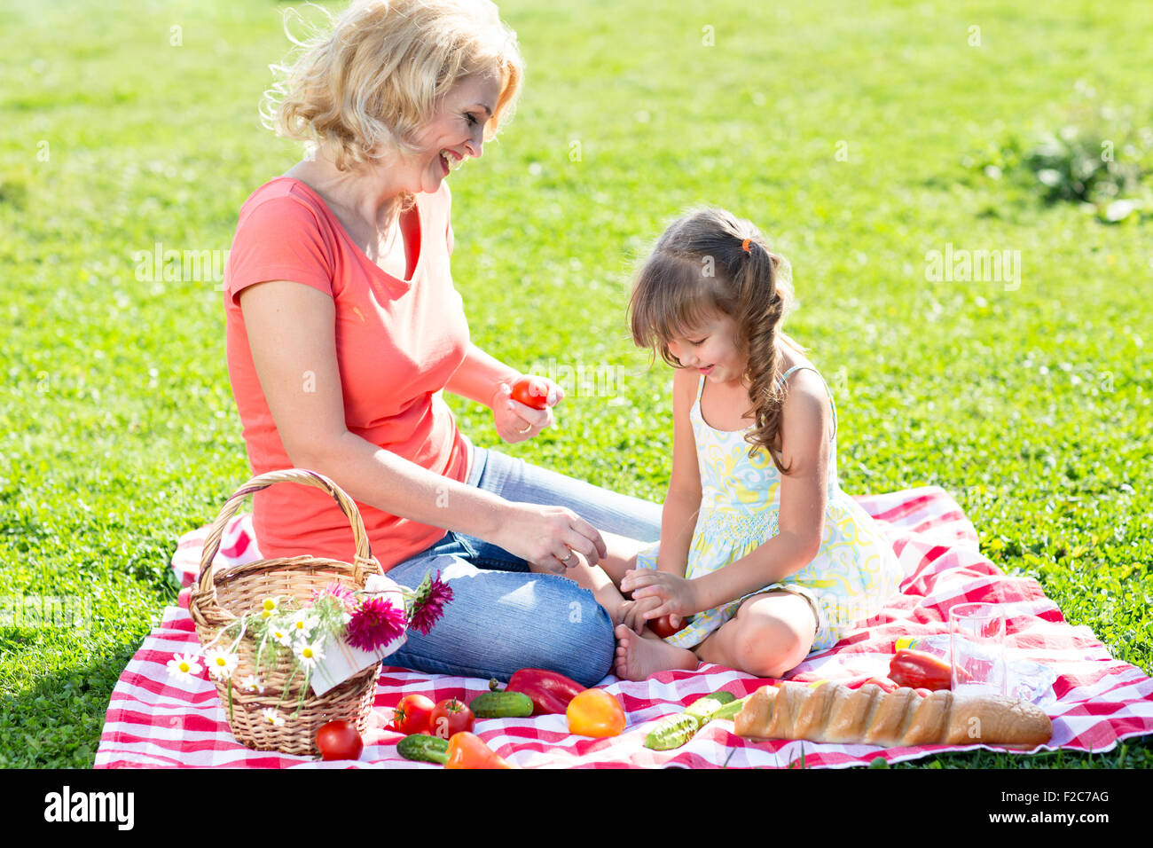 Bella di mezza età madre e figlia avente picnic nel parco in una giornata di sole Foto Stock