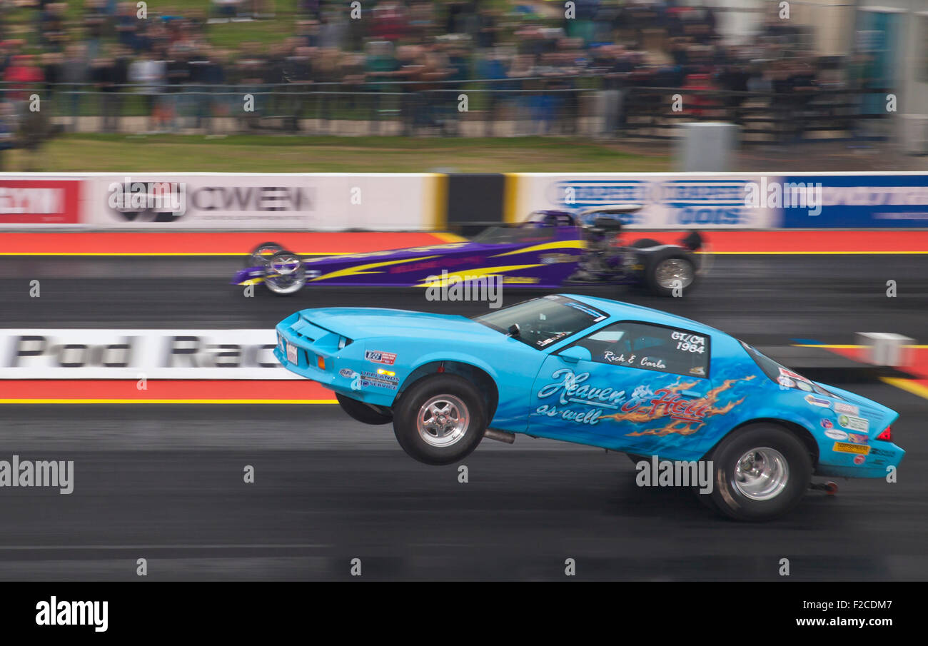 Pro ET Drag racing a Santa Pod. Rick McCann impennare fuori dalla linea di partenza nella sua Chevy Camaro v Rhiannon Bellenie nel suo dragster Foto Stock