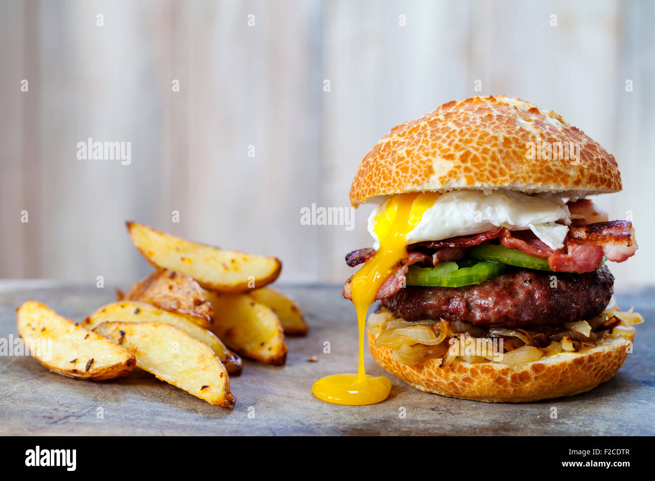 Hamburger di manzo con pancetta e uova in camicia Foto Stock