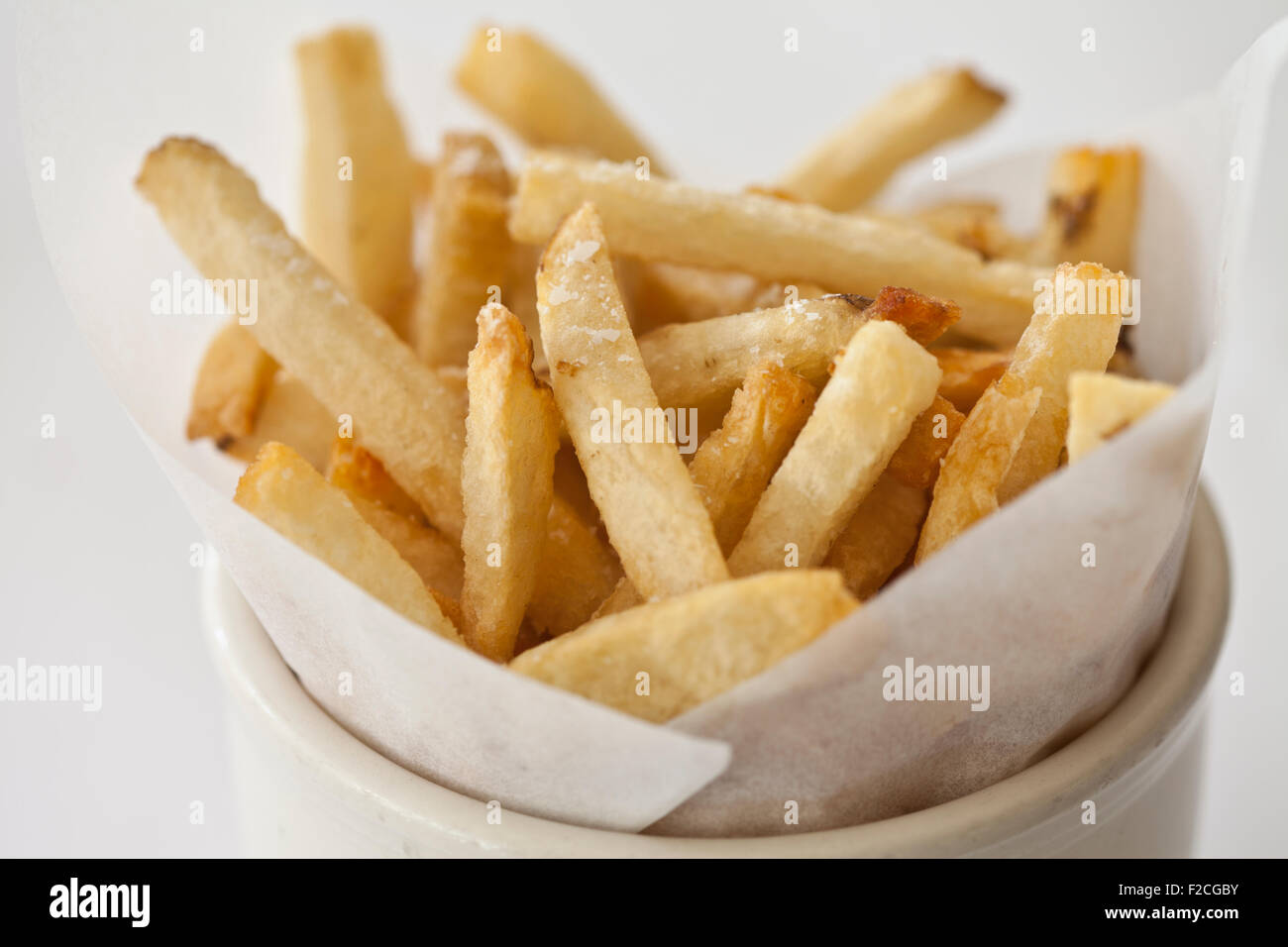 Lato di patatine fritte nel piatto bianco, vista laterale Foto Stock