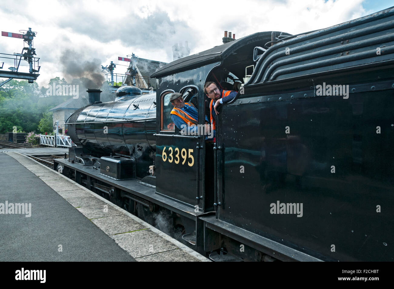 Driver e vigile del fuoco su LNER Q6 0-8-0 n. 63395 locomotiva a vapore a Grosmont stazione sul NYMR, nello Yorkshire, Inghilterra, Regno Unito Foto Stock