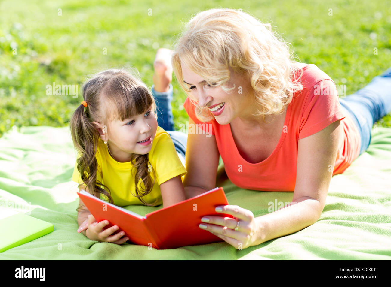 Madre e figlia nel parco libro di lettura Foto Stock